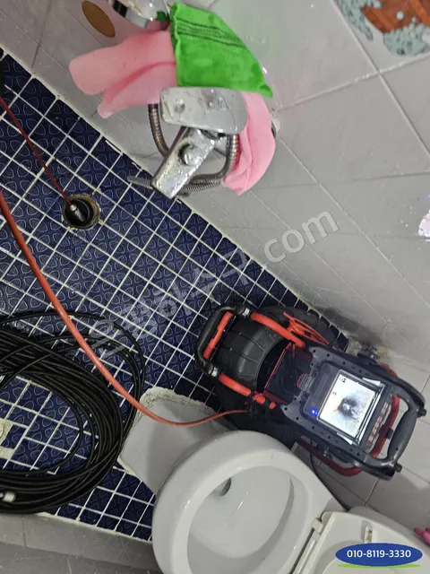 변기 옆 바닥 배수구에 내시경 카메라를 넣고 모니터를 켠 모습