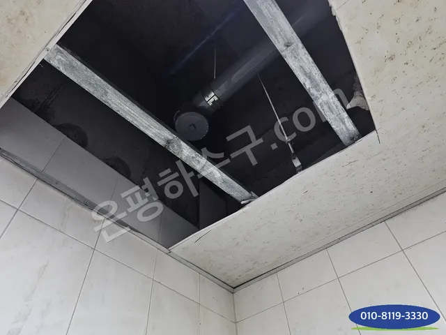 천장 점검구 판을 열어 배관 공간을 드러낸 모습